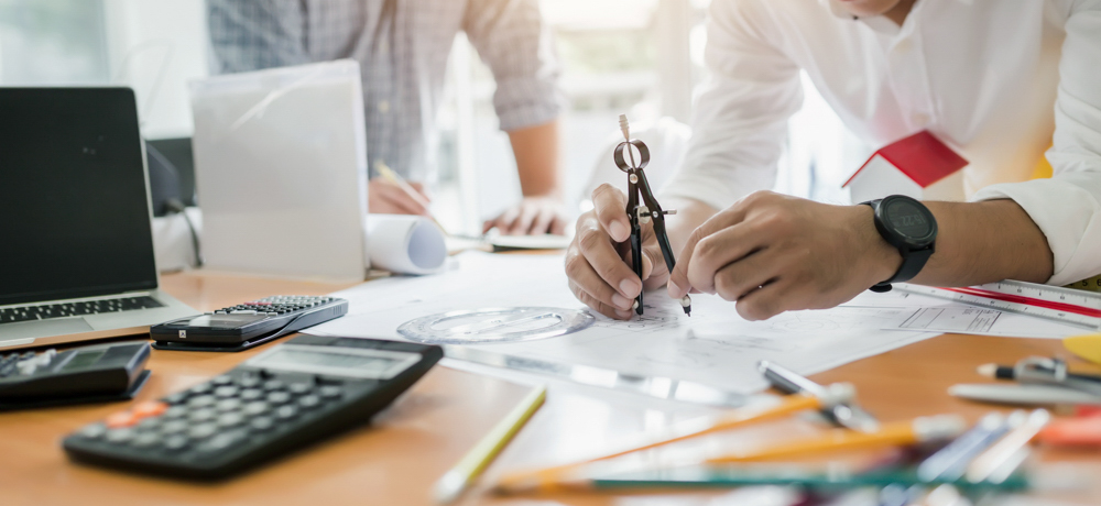 Ingenieure arbeiten gemeinsam an Besprechungen und planen Bauprojekte am Schreibtisch im Büro.