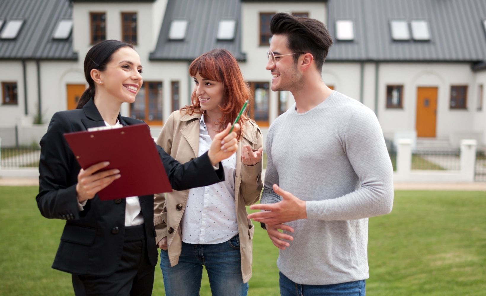 Zwei Immobilienkauffrauen und ein Immobilienkaufmann sprechen über ein Objekt.