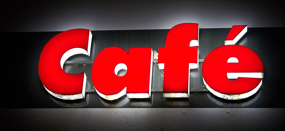 Die Reklame eines Cafés wurde mit Lichteffekt angebracht und leuchtet rot.