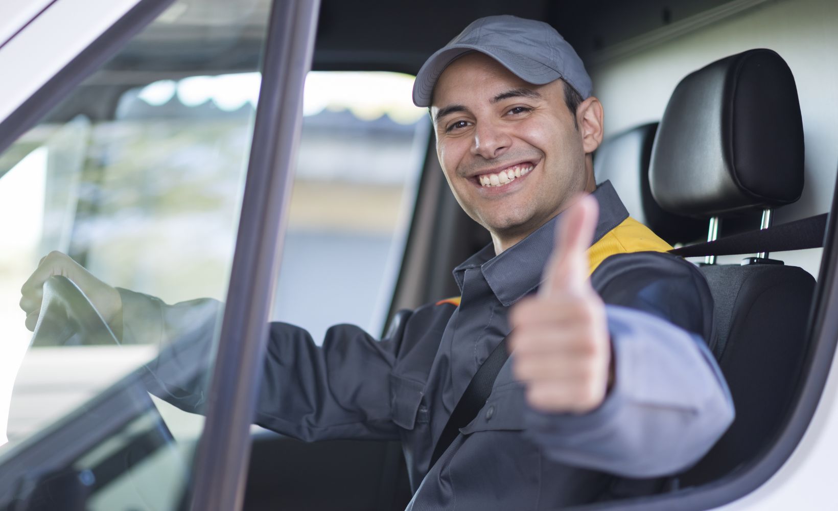 Ein Servicefahrer hält lächelnd den Daumen in die Kamera.