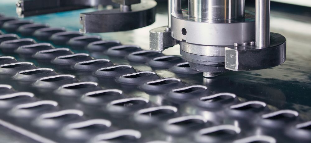 Eine Maschine stanzt Löcher. Es wird der Beruf als Stanz- und Umformmechaniker vorgestellt.