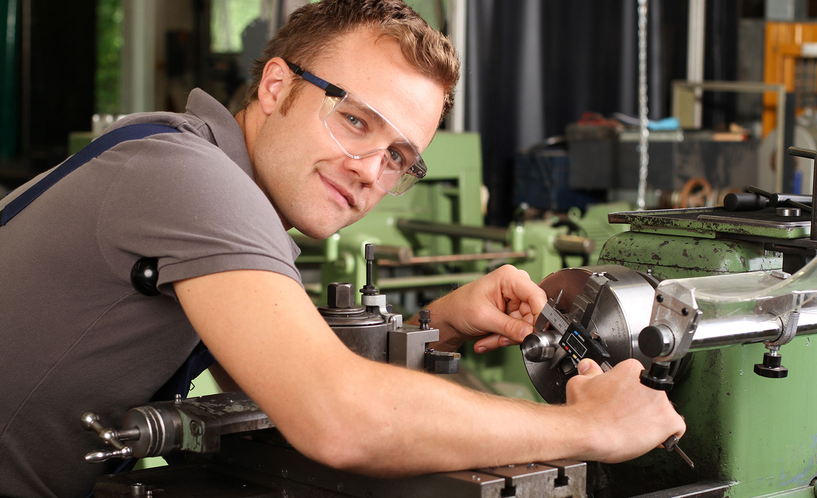 Ein junger Zerspannungsmechaniker arbeitet an einer Maschine.