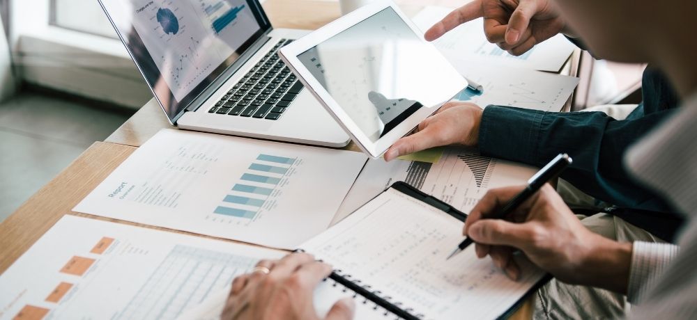 Manager*innen Team arbeiten am digitalen Business mit Laptop, Tablet und Dokumenten.