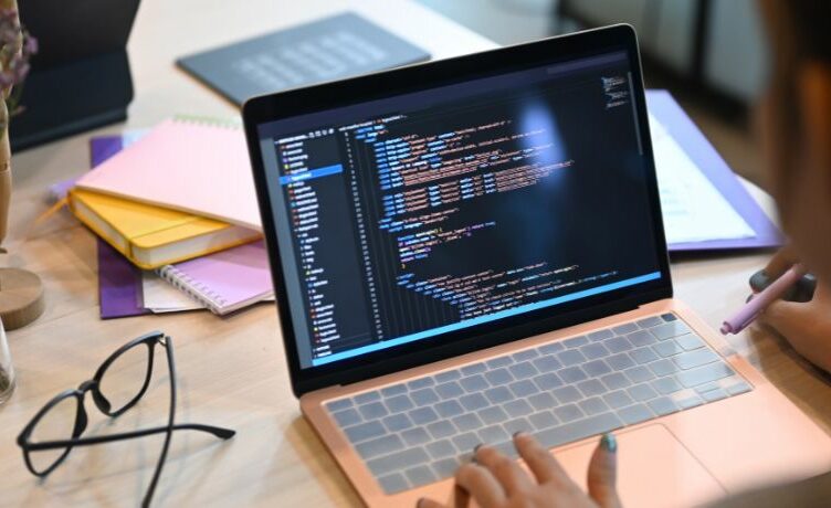 Student*in arbeitet am Laptop an einer Programmierung.