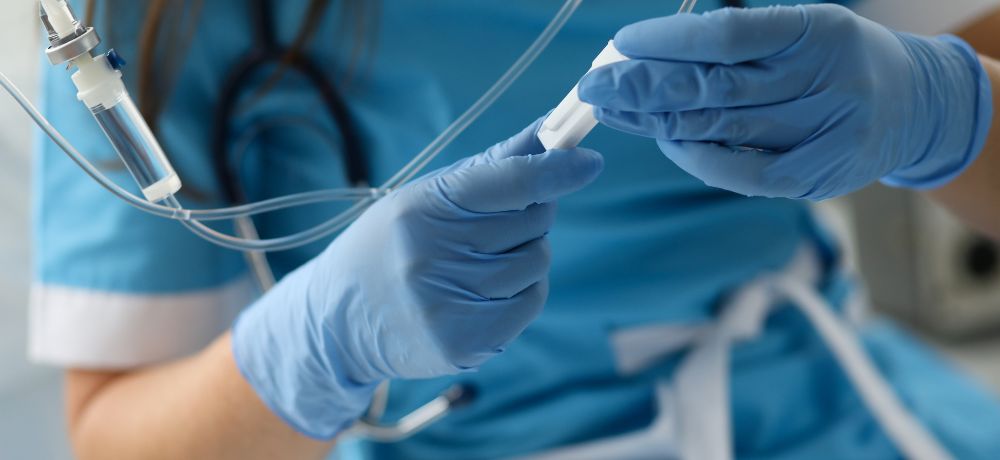 Gesundheits-und Krankenpflegehelfer bereitet eine Infusion vor.
