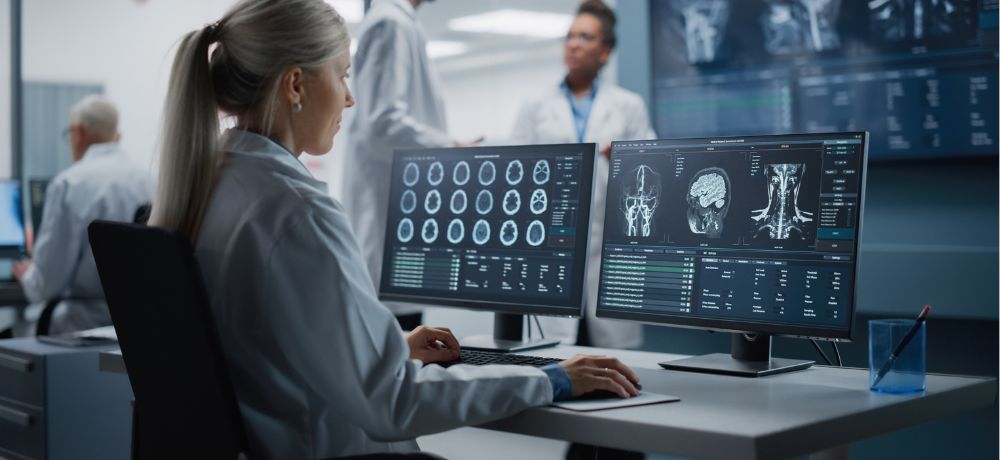 Medizinisch technischer Radiologieassistent arbeitet am Computer