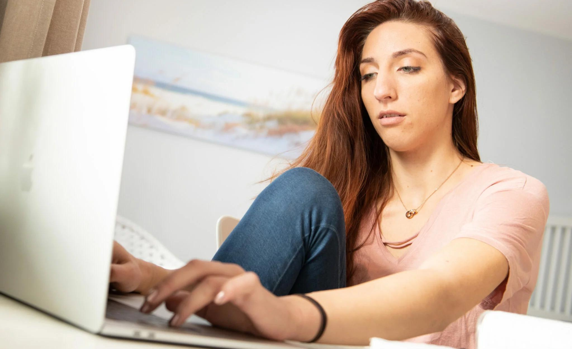 Eine Frau schreibt eine Hausarbeit an ihrem Laptop.