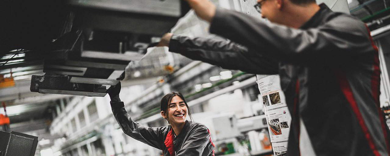 Eine Frau und ein Mann arbeiten im Autowerk.