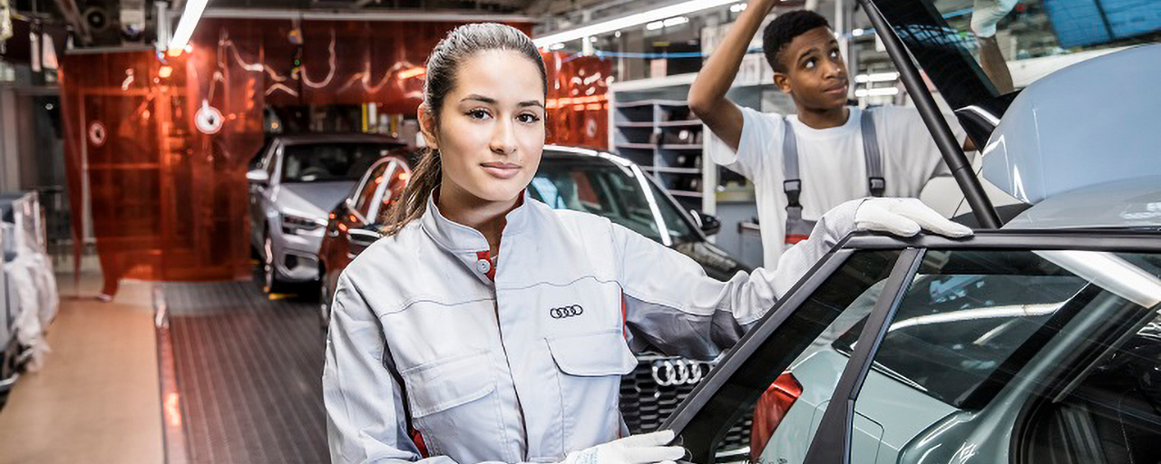 Zwei AUDI-Mitarbeitende arbeiten an Autos.
