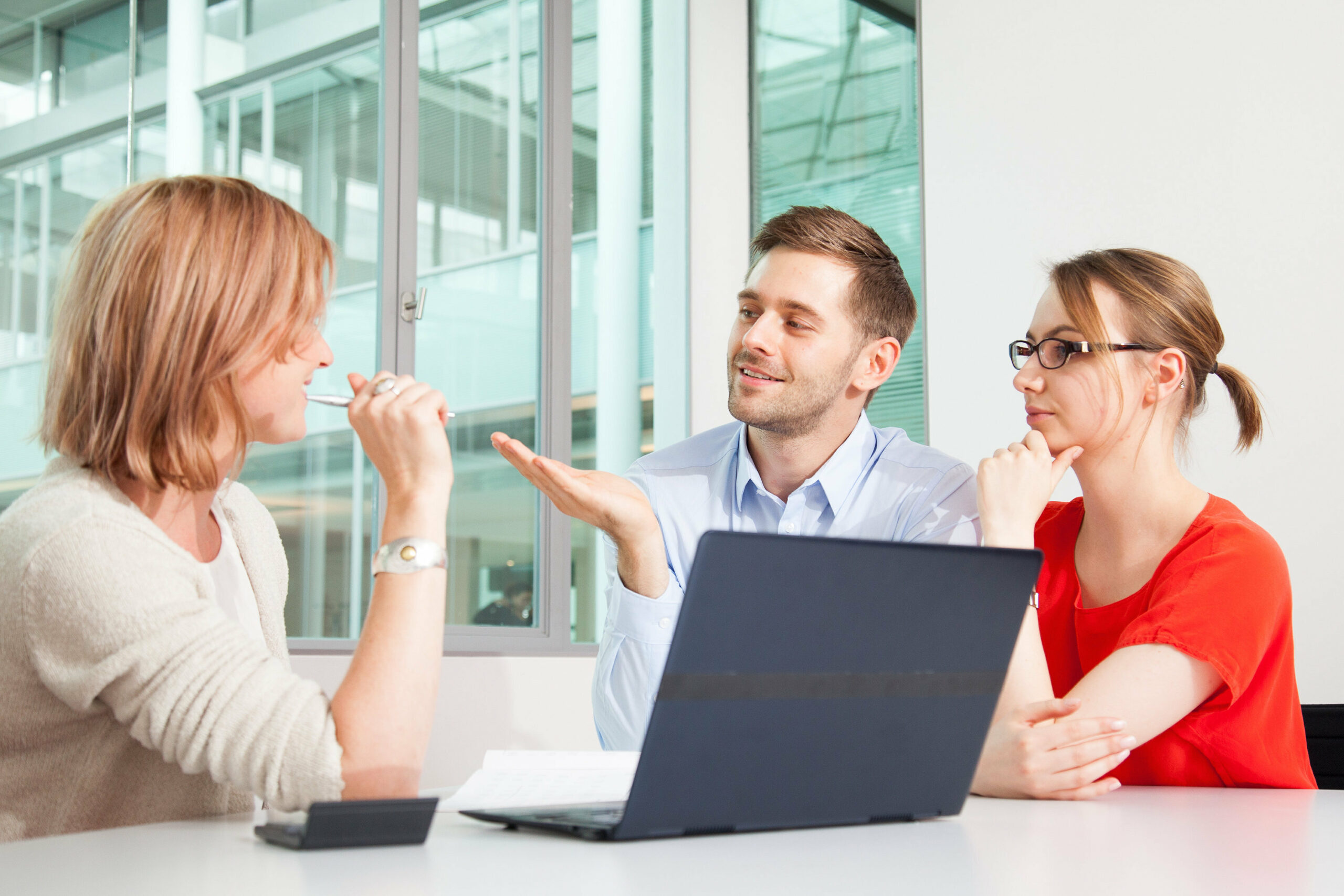 In einem Büro unterhalten sich mehrere Kollegen. Fehler zum Start in einen neuen Job sind dabei durchaus denkbar.