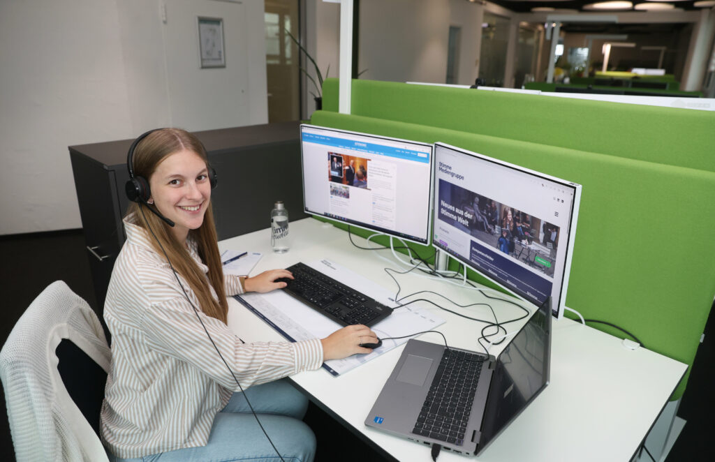 Greta Hofmann während ihres Dualen Studiums bei der Stimme Mediengruppe an einem Büroplatz vor dem PC.