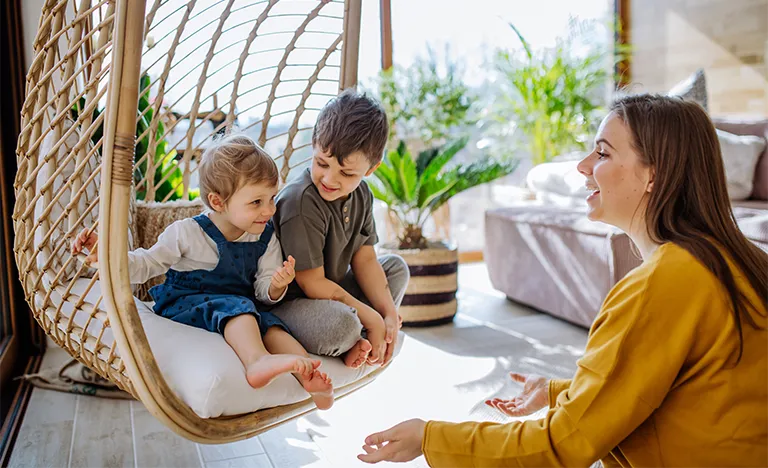 Ein Au-Pair unterhält sich mit zwei Kleinkindern