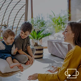 Ein Au-Pair unterhält sich mit zwei Kleinkindern