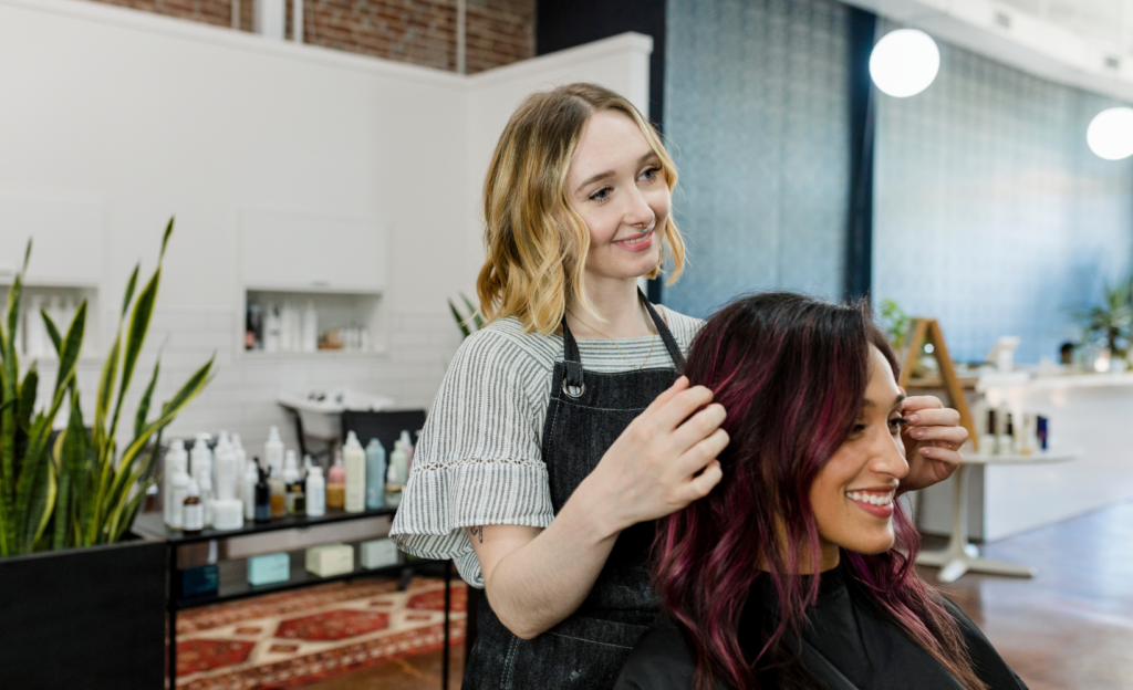 Eine Friseuse bedient eine Kundin und gehört zu den Top fünf der schlechtbezahltesten Ausbildungsberufen.