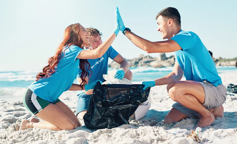 Freiwilligenarbeit & Workcamps: Eine Gruppe Jugendlicher sammelt Müll am Strand