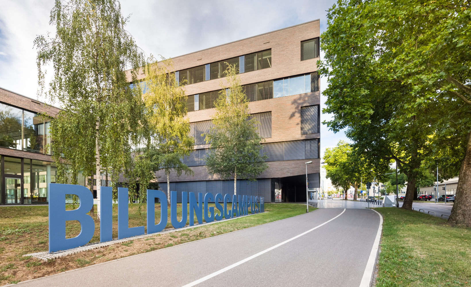 Blaues Schild "Bildungscampus" vor dem Campus Gebäude