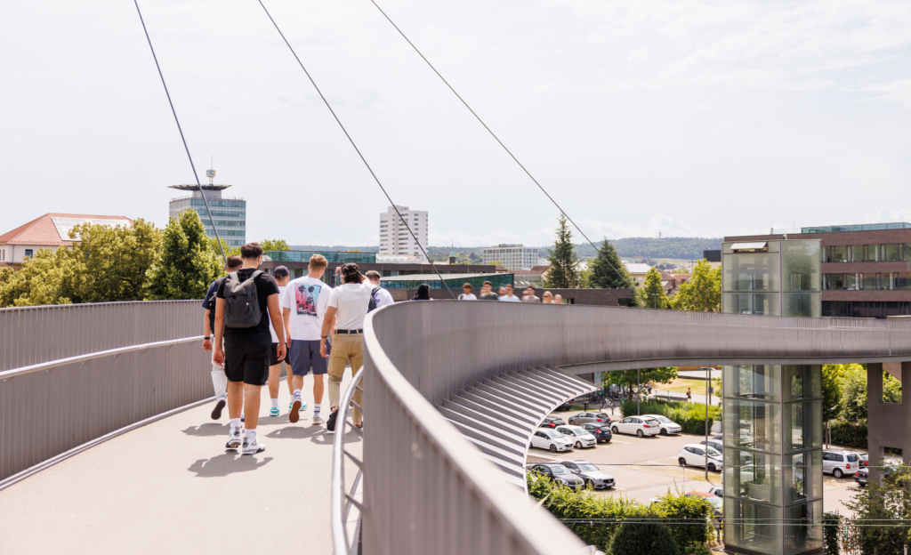 Studenten der TUM Laufen über ein Brücke zum Campus der TUM